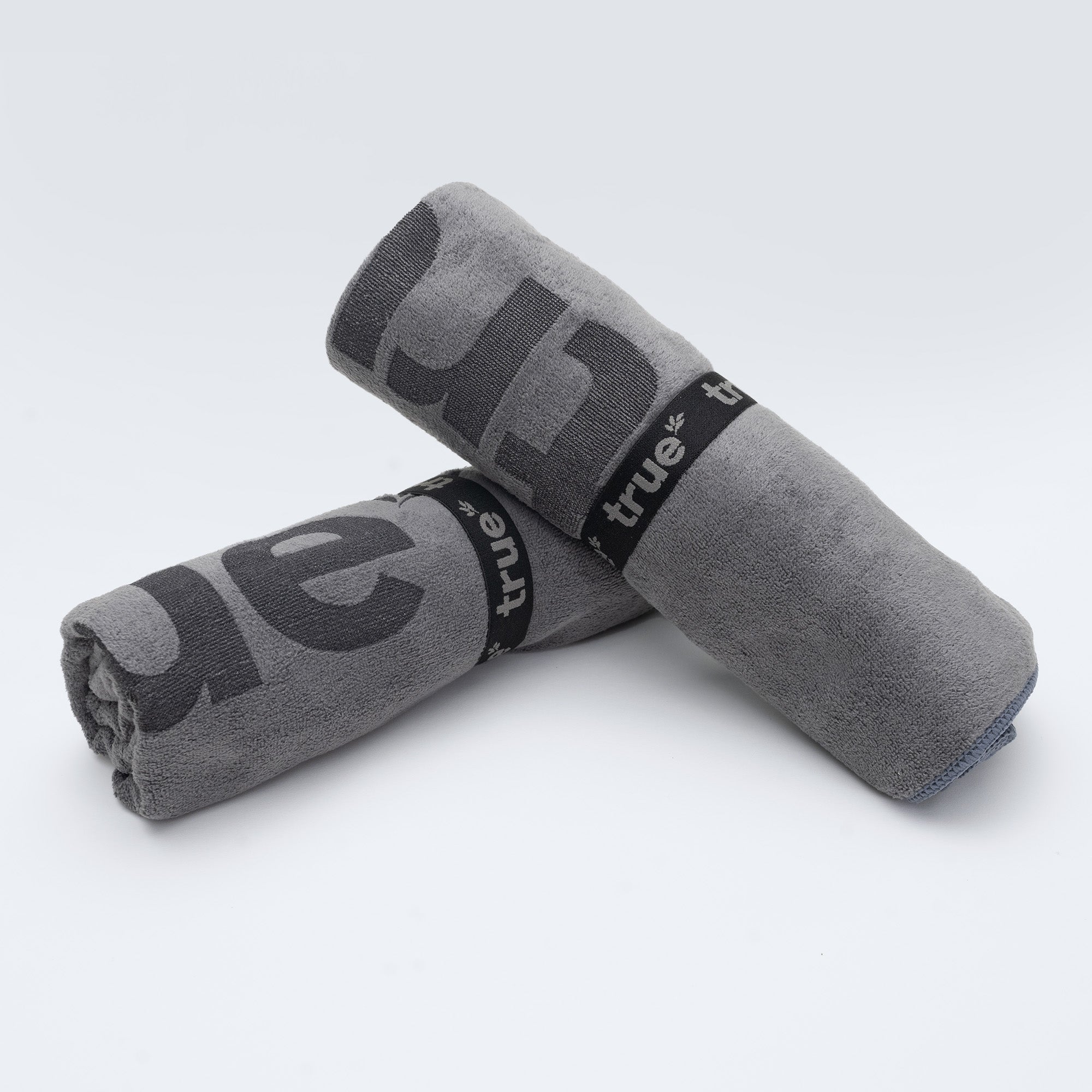 Grey rolled microfiber gym towels with black "true" logo bands, workout/fitness towel for gym, travel and sports.