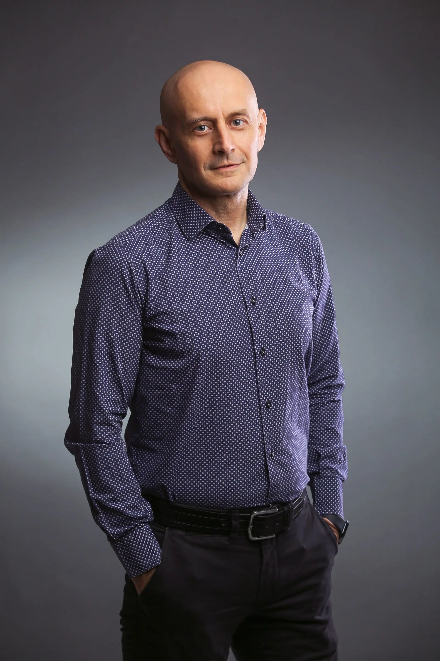 Professor Sergej M. Ostojic wearing a patterned shirt against a grey backdrop