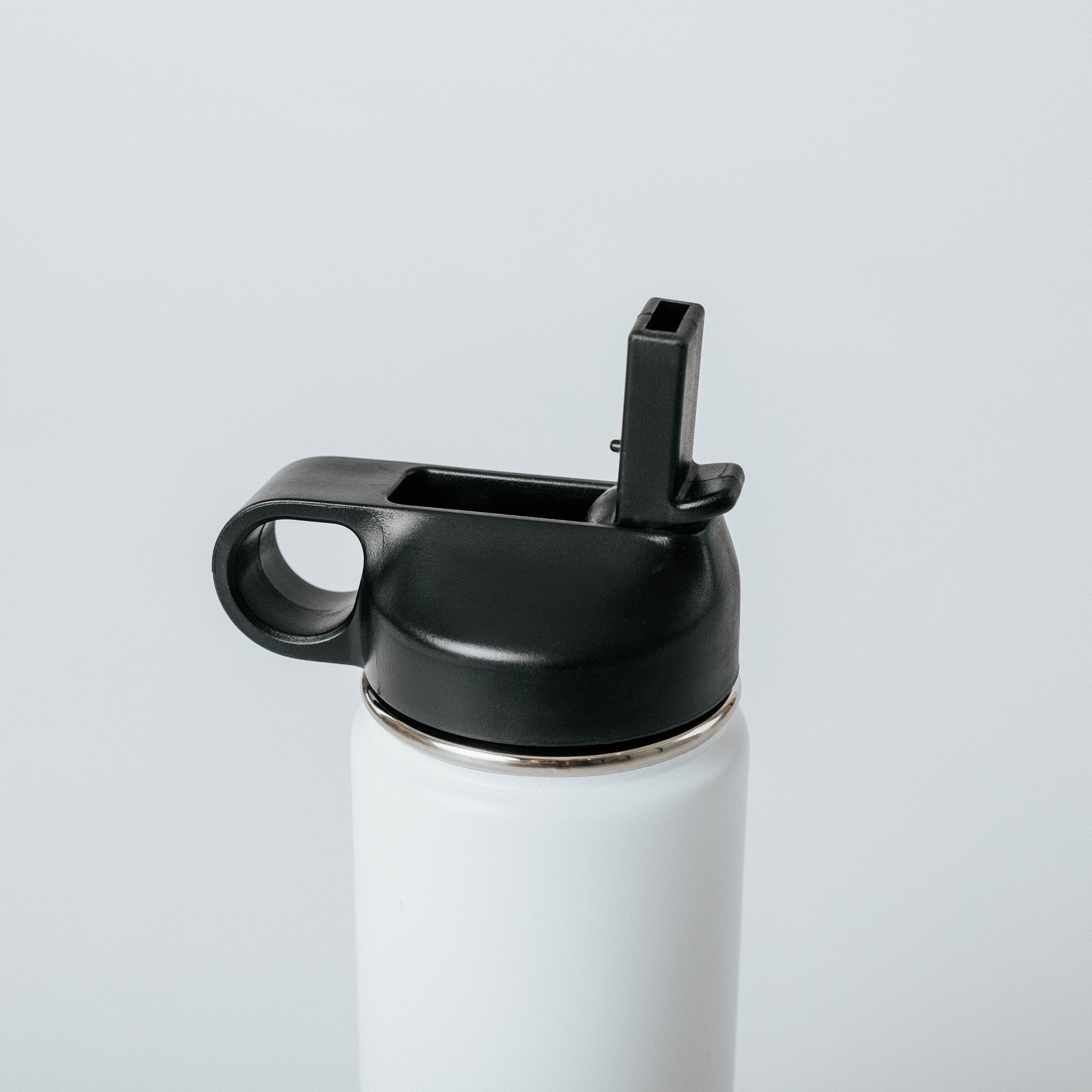 White stainless steel insulated water bottle with black flip-up straw lid and loop handle, close-up product shot on light gray background.