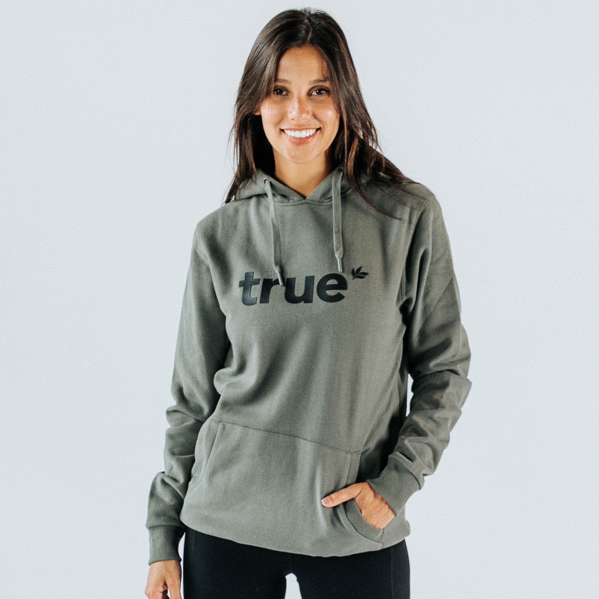 Woman wearing khaki "true" logo pullover hoodie with drawstring hood, kangaroo pocket and long sleeves — women&