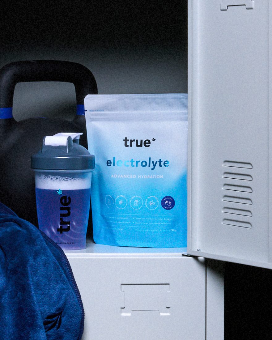 True Electrolyte pouch next to a True shaker, kettlebell and towel inside an open gym locker