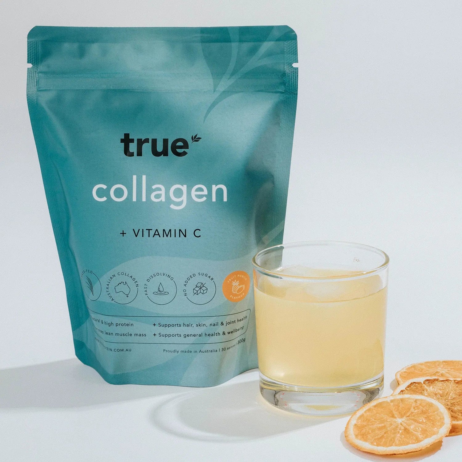 True Collagen powder + Vitamin C citrus punch flavor pouch beside a prepared glass of collagen drink and dried orange slices — Australian-made collagen supplement.