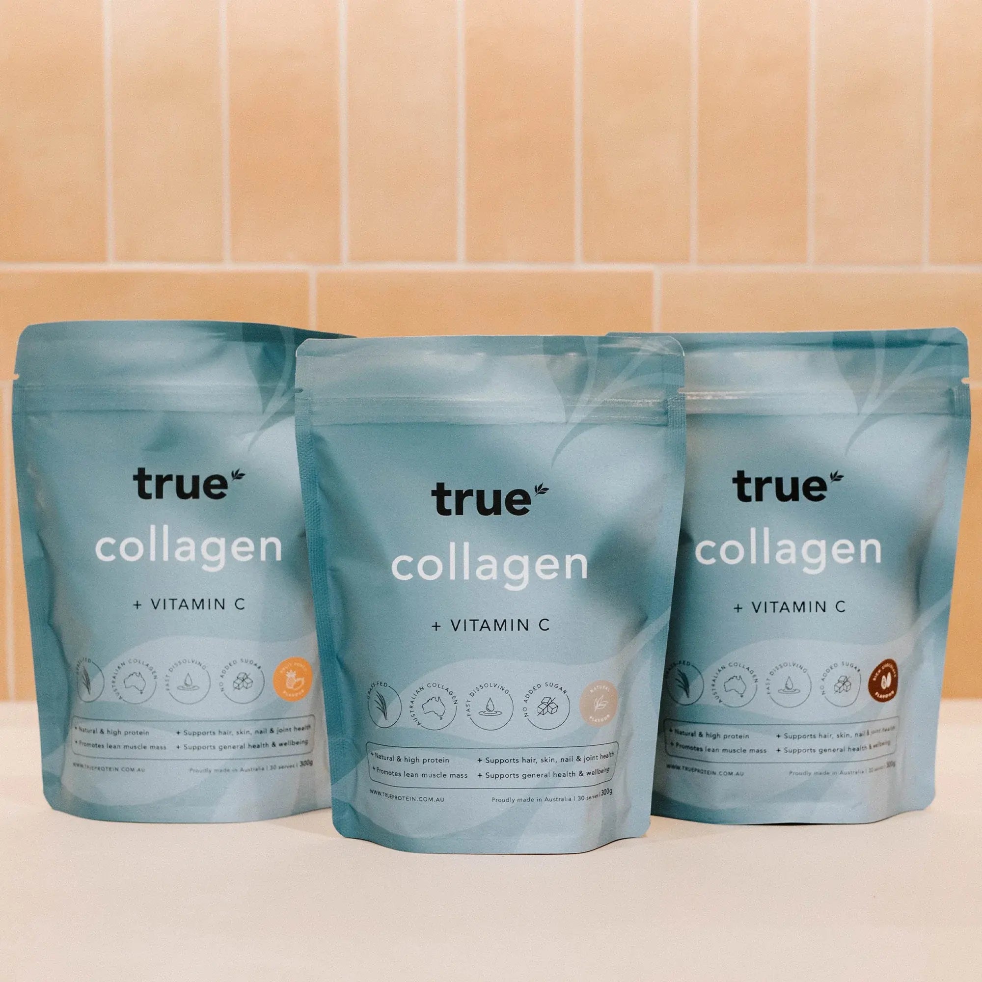 True Collagen + Vitamin C resealable pouches – three turquoise collagen powder supplement bags on a tiled counter (product packaging, Australian brand)