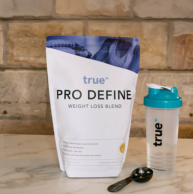 True Pro Define weight loss protein powder pouch with branded teal shaker bottle and scoop on marble counter, Australian-made meal replacement supplement for fat loss and muscle support