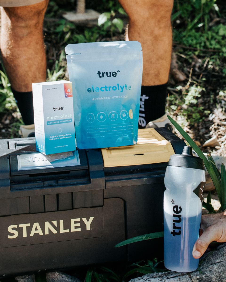 True Electrolyte 240g pouch, Travel Pack and a True drink bottle on a toolbox at a work site